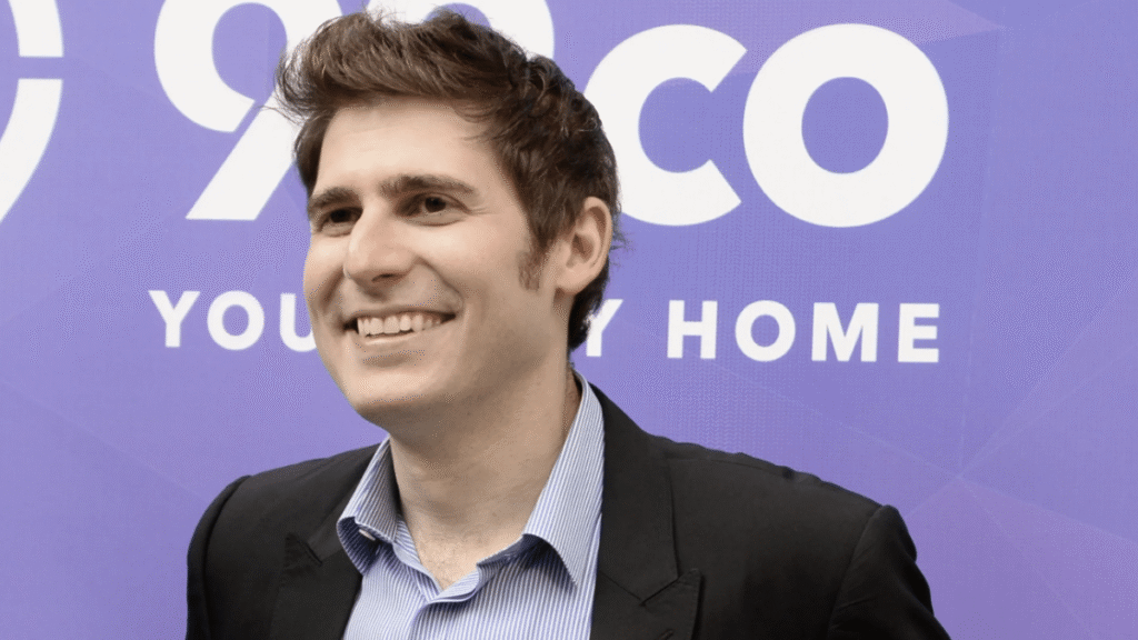 Eduardo Saverin, The Top Tech Billionaire In Singapore, Smiling In A Formal Suit With A City Skyline In The Background, Representing His $29 Billion Net Worth In 2024.